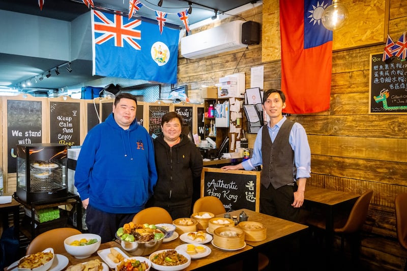 Aquila香港餐厅内挂着两面显著的、挑战中共神经的旗帜。图为两位创办人和店长的合照。(摄影/陈希伦)