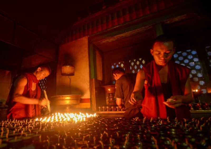 A Nepalese monk lights a butter lamp during Saga Dawa at Swayambhunath, one of the holiest Buddhist stupas in Nepal, in Kathmandu, May 24, 2013. (Prakash Mathema/AFP)