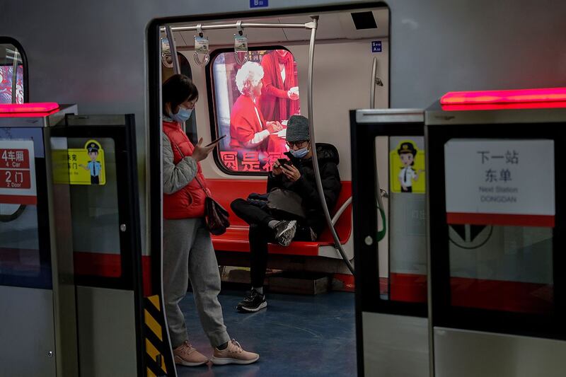 北京地铁列车内,乘客浏览智能手机。 (美联社)