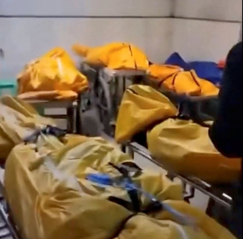 Several body bags are lined up around the level at a loading bay in a building in Chongqing, China, in this image released Thursday, Dec. 22, 2022. Credit: Reuters screenshot from video
